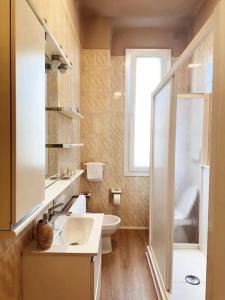 une salle de bain avec un lavabo et des toilettes et une fenêtre dans l'établissement Casa Chanel, à Vicence