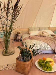 a tent with a plate of grapes and a basket of fruit at Järveääre Glämping in Jõeranna