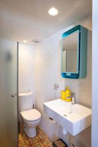 a bathroom with a sink and a toilet and a mirror at Cozy Tiny House in Neve Tzedek, 3m walk to Beach! in Tel Aviv +13 photos