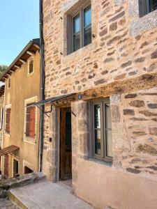 an entrance to a stone building with a door at La Bohème, Maison de bourg in Chaudes-Aigues +39 photos