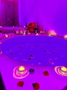 a purple room with two plates and candles on a table at Mael Superior Room in Palermo