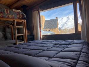 a bed in a room with a large window at Refugio Inka in Los Molles