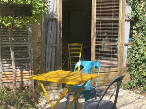 a yellow table and chairs in front of a house at L'Atelier in Sarlande