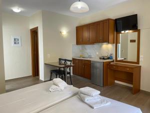 a kitchen with wooden cabinets and a table and a counter at TRIANTAFYLLOY ROOMS in Loutra Edipsou