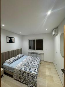 a bedroom with a bed and a window at The pearl of Aouina - Modern Splus2 luxurious apartment in La Goulette