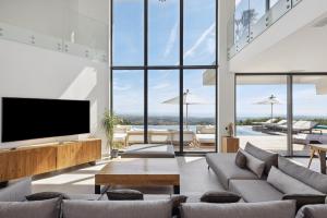 a living room with a tv and large windows at Villa Y in Vence