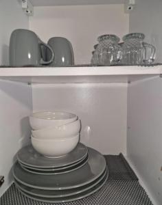 a stack of bowls and plates on a shelf at Laubach Apartments in Laubach