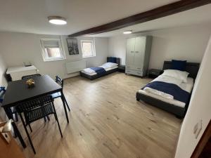 a bedroom with two beds and a table and a desk at Laubach Apartments in Laubach