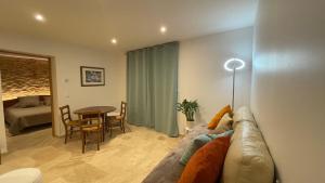 ein Wohnzimmer mit Sofa und Tisch in der Unterkunft L'Oxalis doré in Frontenas