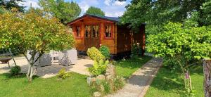a small wooden cabin in a yard with trees at Chalet dans notre jardin in Parigné