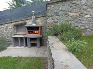 a stone building with an outdoor oven in a yard at Appartamento BIJOU in Aosta