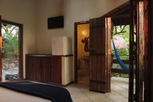 a room with a refrigerator and a sliding glass door at Chalé do Bosque in Bonito