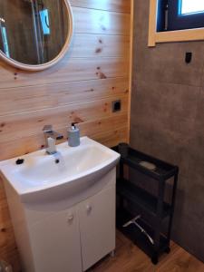 a bathroom with a white sink and a mirror at Domek Arkadia in Gąski +20 photos