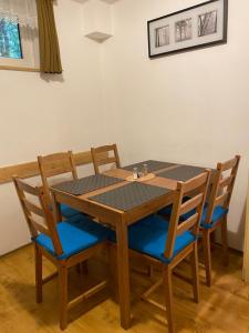 a wooden table with four chairs around it at Samostatný apartmán se zahradou in Bedřichov +25 photos