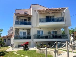 a large white building with balconies and a yard at Villa Nikiti View semi-basement in Nikiti
