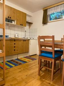 a kitchen with a wooden table and a wooden chair at Samostatný apartmán se zahradou in Bedřichov +22 photos