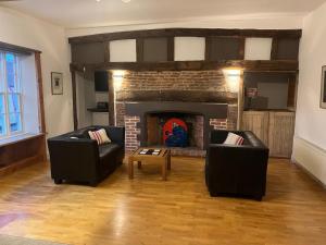 a living room with two couches and a fireplace at Rooms at number 3 in Harleston