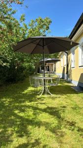 un tavolo con ombrellone in erba di Hotell Lamar ad Ängelholm Altre 4 foto