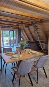 a dining room with a wooden table and chairs at Mountain A-Frame Resort , com Avram Iancu in Budeşti +39 photos