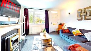 a living room with a couch and a fireplace at Sleeps 10, Free parking, close to Science Park, King size bed in Milton