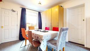 a dining room with a table and chairs and a window at Sleeps 10, Free parking, close to Science Park, King size bed in Milton