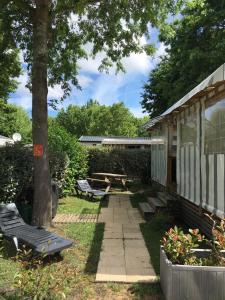 a backyard with a picnic table and a bench at Mobilhome neuf au camping La Réserve in Gastes