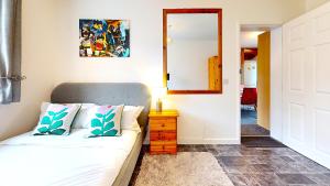 a living room with a couch and a mirror at Sleeps 10, Free parking, close to Science Park, King size bed in Milton