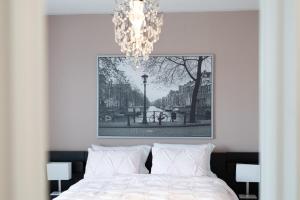 a bedroom with a bed with a chandelier above it at 4br Near Hilton Falls - Kelso - Gazebo, Workspace in Milton