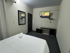 ein Schlafzimmer mit einem Bett und einem Flachbildfernseher in der Unterkunft Habitación en el centro asunción solo efectivo guaranies in Asunción