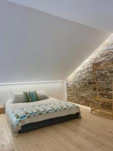 a bedroom with a bed and a stone wall at Turismo e Alojamento dos Lagos do Sabor - Piscina & SPA in Meirinhos
