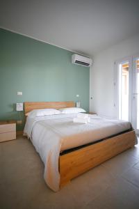 Un dormitorio con una cama grande con cabecero de madera. en Dimore degli Ulivi, en Leporano 16 fotos más