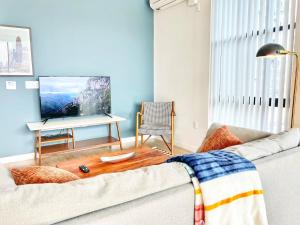 Una sala de estar con un sofá y un televisor de pantalla plana. en Downtown San Diego Getaway, en San Diego