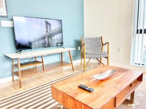 Una sala de estar con una mesa y un televisor. en Downtown San Diego Getaway, en San Diego