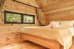 Novi VladimirovacEspacio Resort - Pool & Spa的小木屋里有一张床的卧室