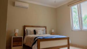 a bedroom with a bed and a window at Hispaniola Beach Condo 9a2oceanviewbeachpool in Sosúa +26 photos