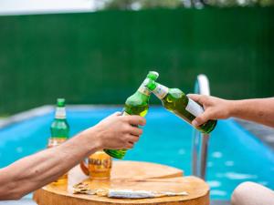 two people are holding beer bottles on a table at Ghazaryan's Home Guesthouse Lori in Debed