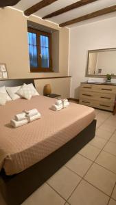 a bedroom with a bed with towels and a dresser at Lacasadeitati in Lecco