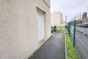 a white door on a building next to a fence at Appartement F2 Villeparisis in Villeparisis