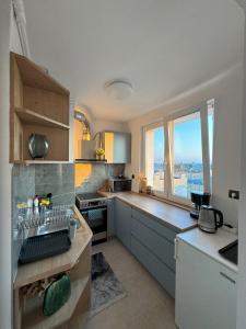 a kitchen with a view of a city from a window at Central City Off Piotrkowska District in Łódź