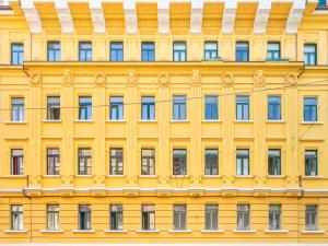 una fachada de un edificio amarillo con ventanas en Garibaldi Luxury Apartment, en Trieste
