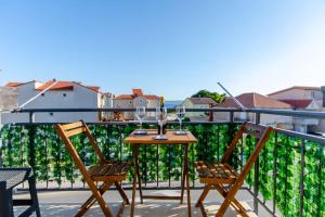 a table and two chairs on a balcony at Cozy stone house close to the beach in Kaštela