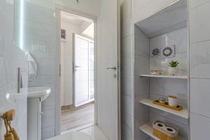 a white bathroom with a sink and a toilet at Cozy stone house close to the beach in Kaštela +62 photos