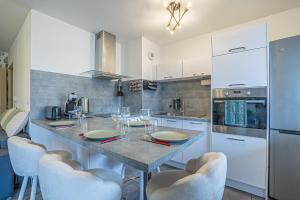 a kitchen with a table with wine glasses on it at Spacieux - 4 pers' - Balcon - 2 lits - Parking in Woippy +6 photos