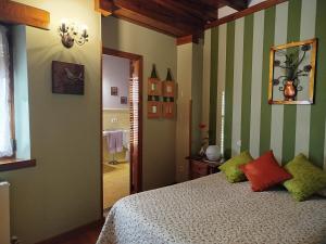 a bedroom with a bed with green and white stripes at Casa Rural Mi Rinconcillo in Valleruela de Pedraza