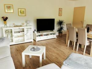 a living room with a television and a table at Ferienwohnung Blick Rappenstein in Hausen am Tann