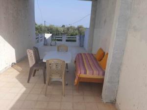 un patio avec une table et des chaises sur un balcon dans l'établissement Appartement deux chambres-calme proche plage, à Ḩammām al Ghazzāz