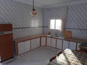une cuisine avec un comptoir, un évier et une fenêtre dans l'établissement Appartement deux chambres-calme proche plage, à Ḩammām al Ghazzāz