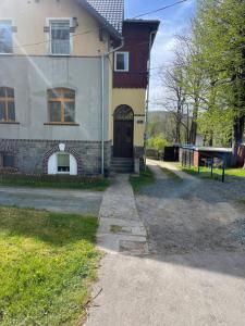 een oud huis met een oprit die naar de voordeur leidt bij Przystanek Karpacz - Komuny Paryskiej 3 in Karpacz