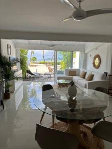 un soggiorno con un tavolo di vetro e un divano di Palm & Sea, 1 chambre sur la plage, Nettle Bay Beach Club a Baie Nettle