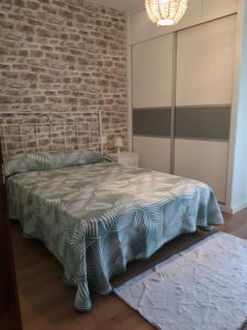 a bedroom with a bed with a brick wall at Casa Lavandeira in Ourense
